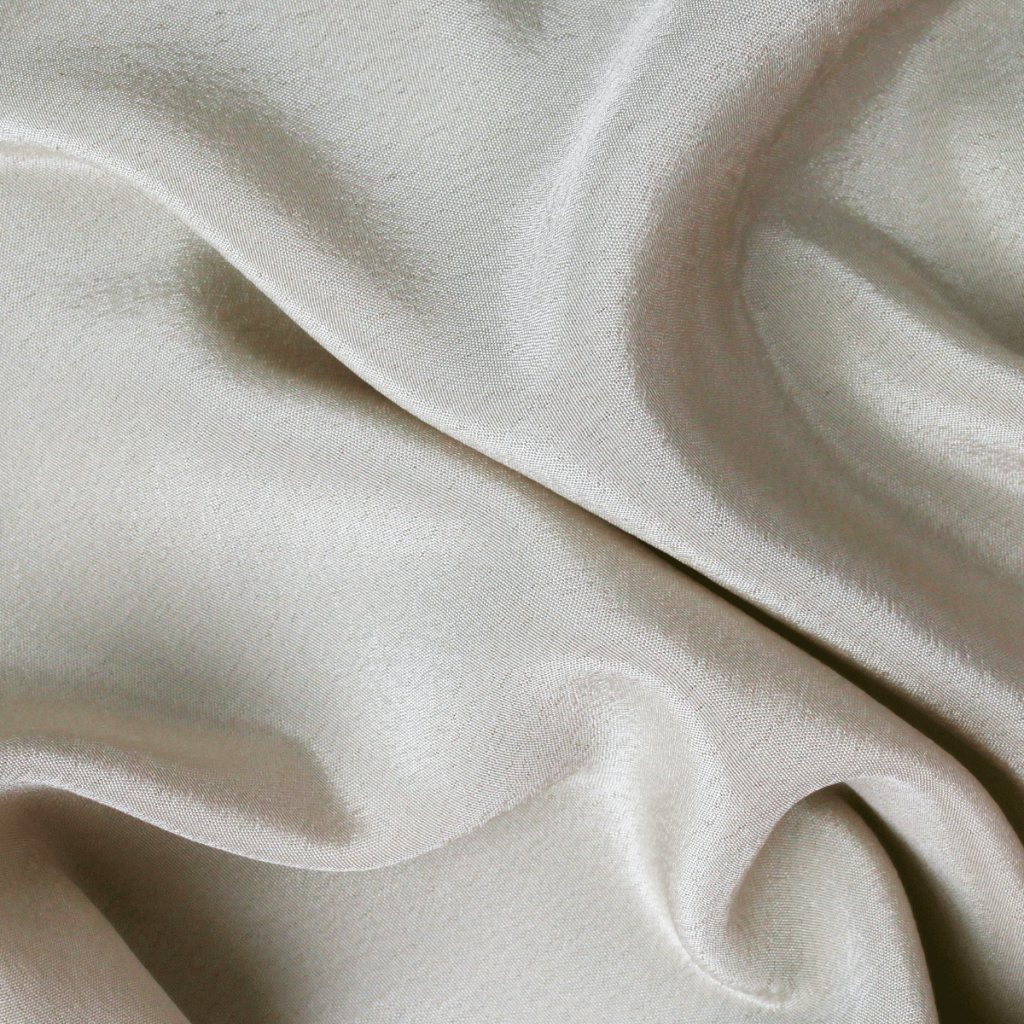 Vibrant rolls of sateen fabric with a silky sheen and intricate designs, embodying the beauty of sustainable textiles and offering endless creative possibilities for fashion and interior design enthusiasts.